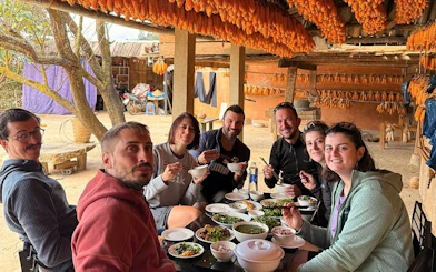 Group enjoying traditional meal during private car tour from Sapa to Mu Cang Chai rice terraces.