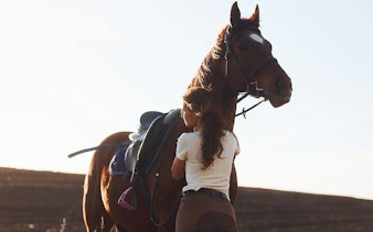 Horseback rider preparing horse in Hurghada desert for Red Sea tour.