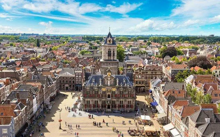 Delft cityscape with historic buildings and central square, part of Brussels to Delft and Keukenhof Gardens tour.