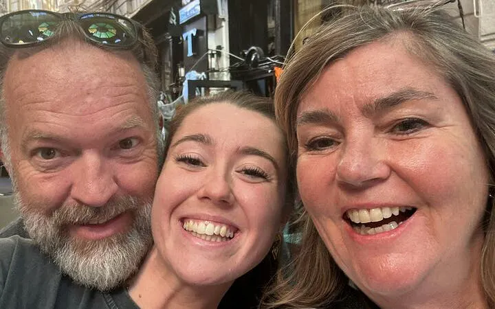 Three people smiling during a self-guided city exploration in Old Town Bucharest.
