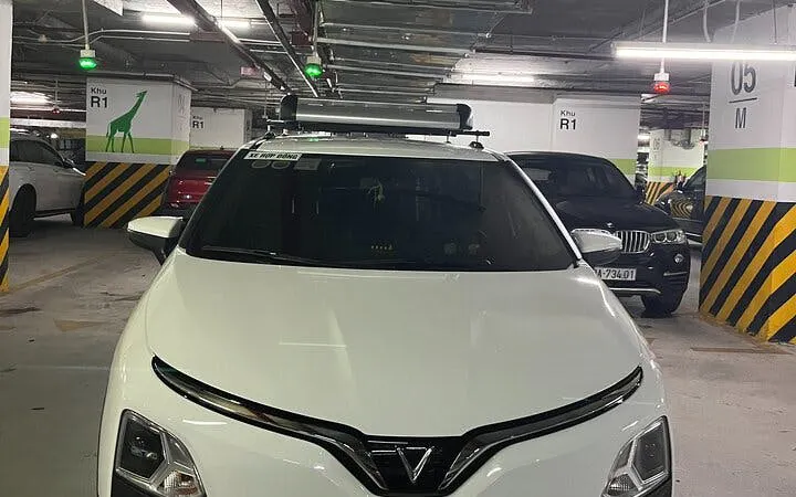 Private car in a parking garage for Sapa to Ha Giang City transfer with local driver insights.