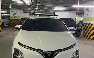 Private car in a parking garage for Sapa to Ha Giang City transfer with local driver insights.