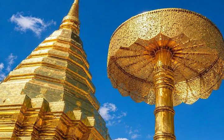 Golden stupa and umbrella at Wat Doi Suthep, Chiang Mai under blue sky.