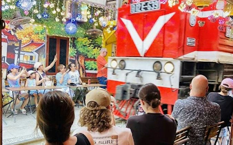 Tourists watch a train pass by at Hanoi's Train Street during a cyclo tour in the Old Quarter.