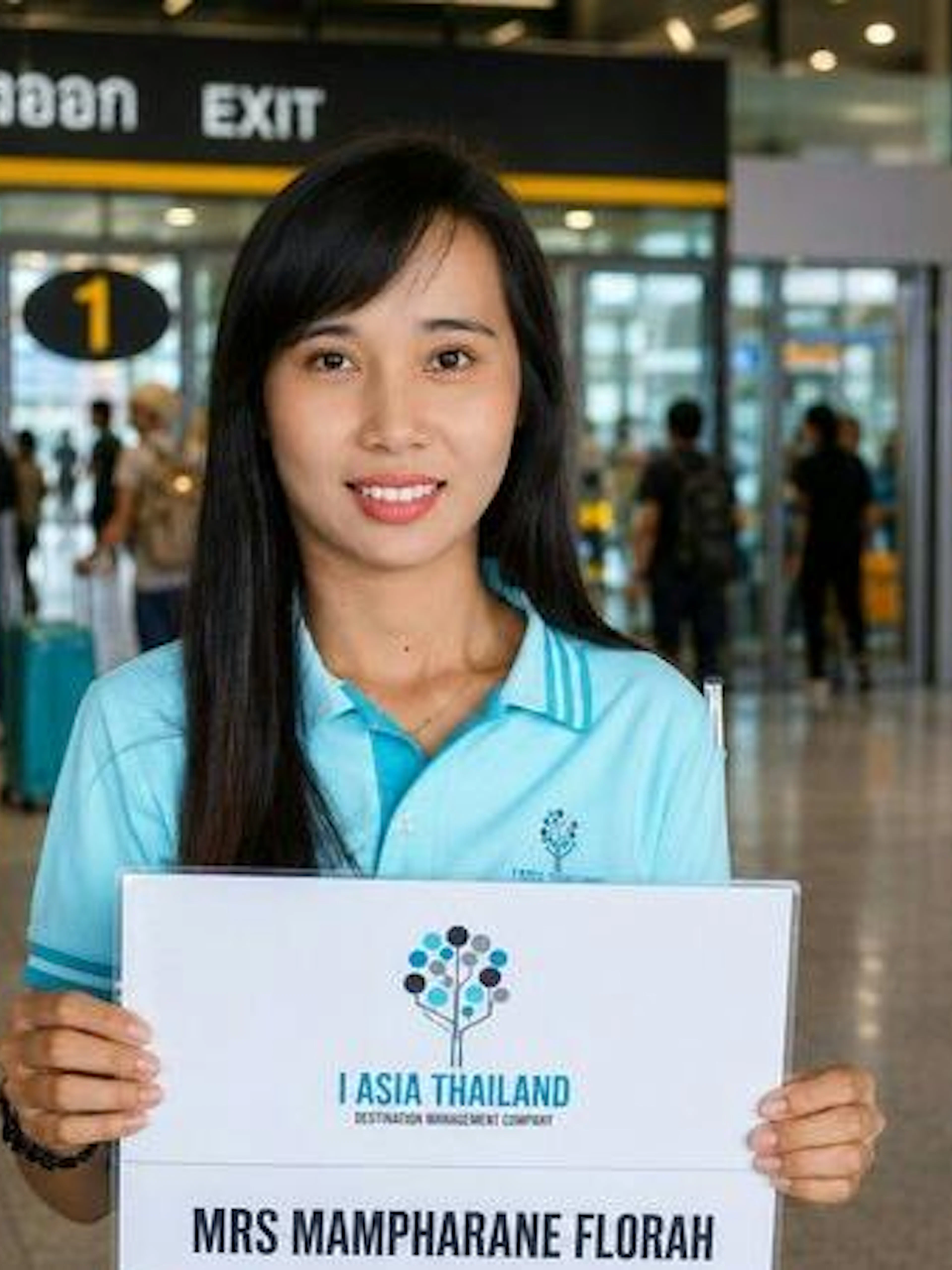 Airport pickup service in Phuket with a driver holding a sign for a private minivan charter.