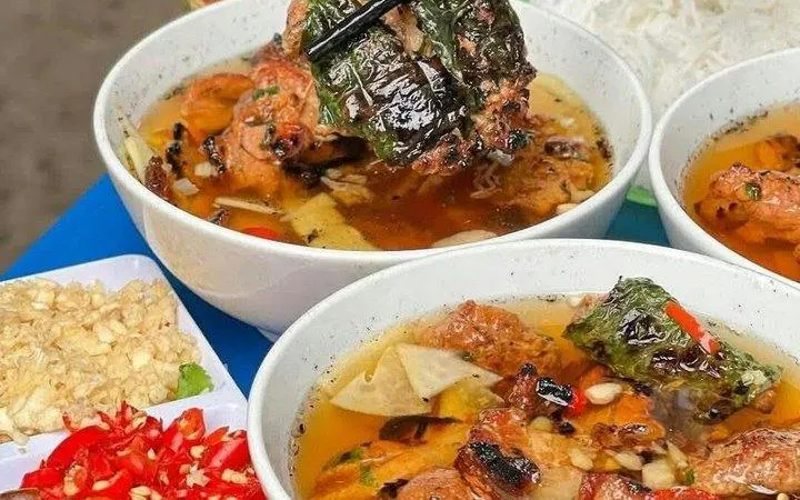 Bowls of Vietnamese bun cha with grilled pork, herbs, and noodles, part of Hanoi E-Scooter City Tour.