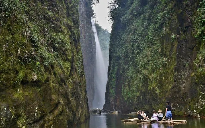 Motorbike tour group on bamboo raft near Dragon Waterfall, Sapa, Vietnam.