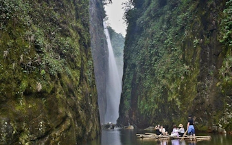 Motorbike tour group on bamboo raft near Dragon Waterfall, Sapa, Vietnam.