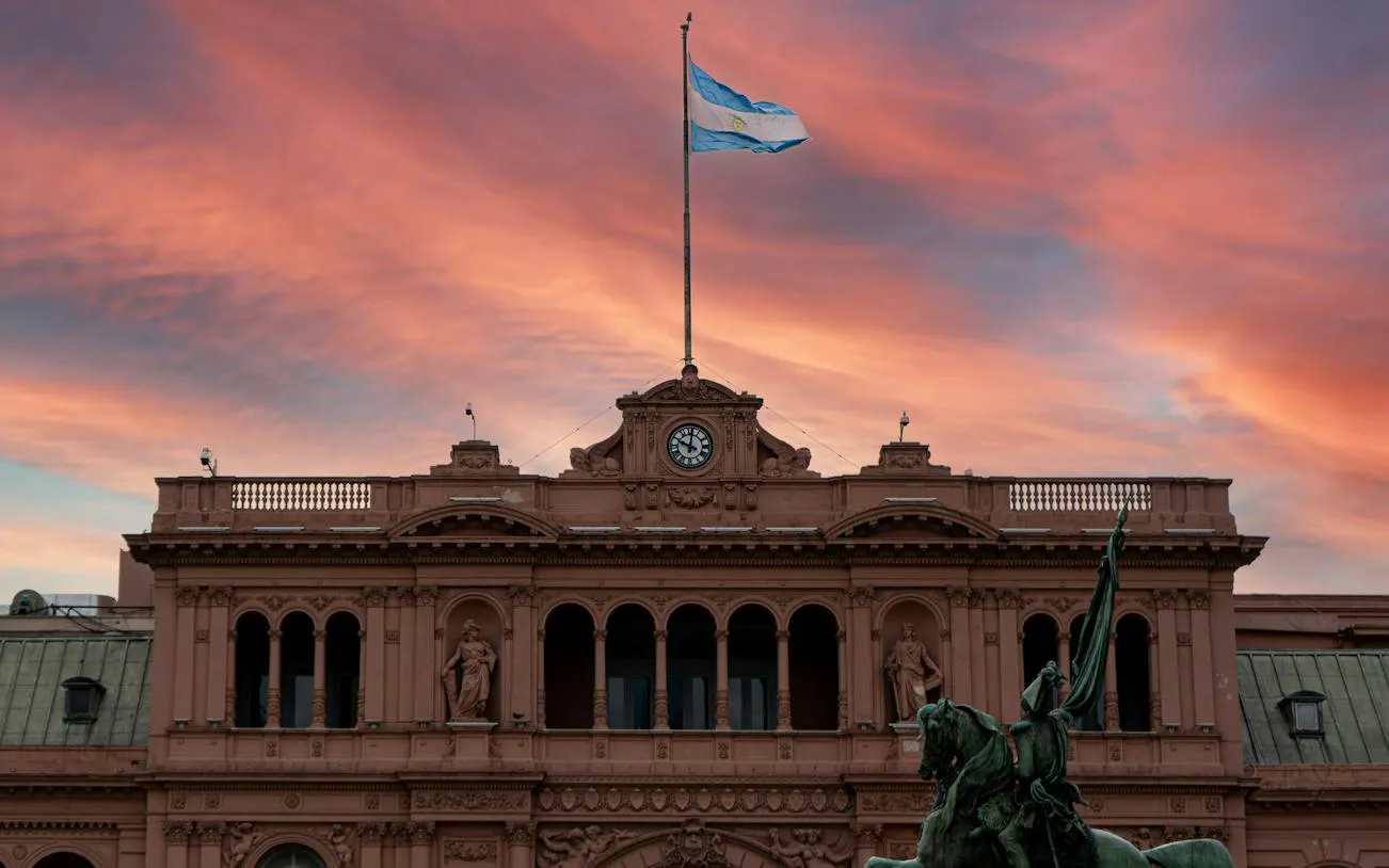 Casa Rosada facade with Argentine flag at sunset, Plaza de Mayo, Buenos Aires.