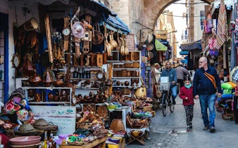 Essaouira market street with local crafts and tourists, part of Marrakech day trip.