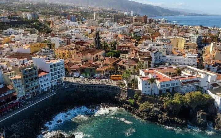 Tenerife coastal cityscape with ocean view, part of self-guided walking tour on mobile app.