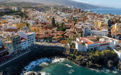 Tenerife coastal cityscape with ocean view, part of self-guided walking tour on mobile app.