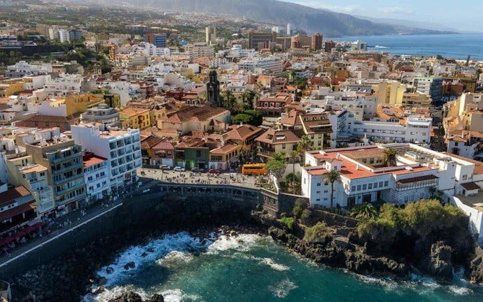 Tenerife coastal cityscape with ocean view, part of self-guided walking tour on mobile app.