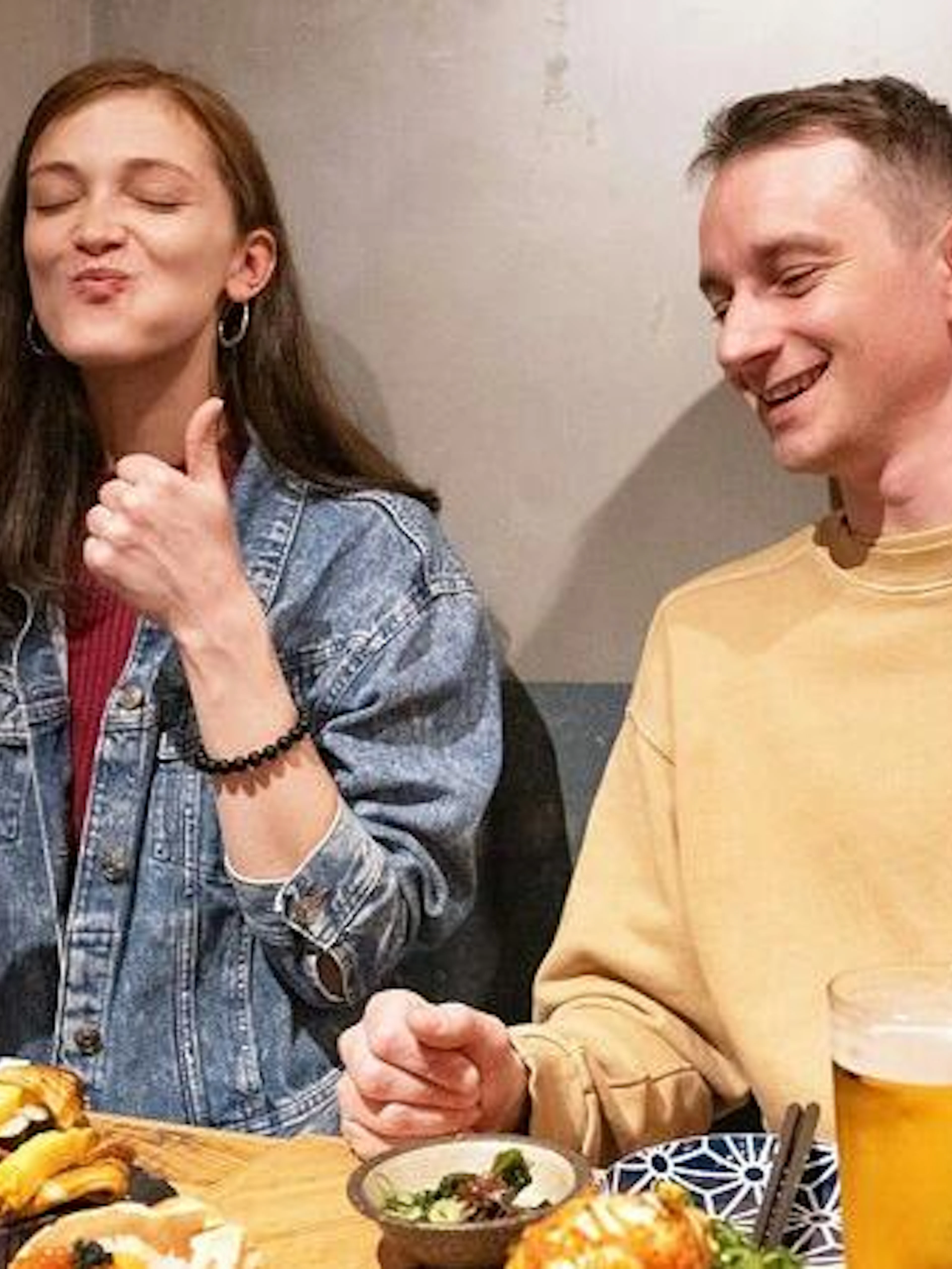 Two people enjoying sushi and drinks at a local eatery in Shinjuku, Tokyo.