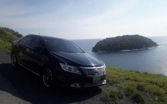 Car parked by the coast with ocean view, Phuket Airport Transfers.