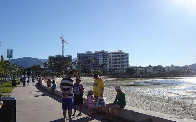Cairns Esplanade with people walking along the waterfront promenade.