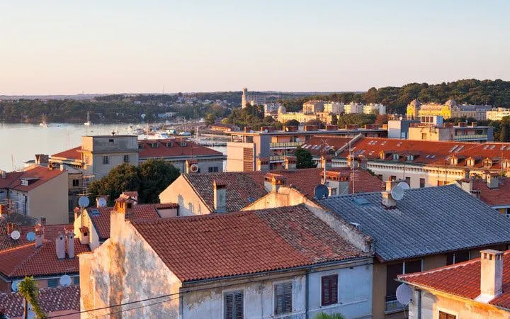 Pula cityscape with red rooftops and Adriatic Sea view during a self-guided walking tour.