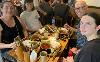 Dining on traditional Vietnamese street food during Hanoi motorbike night tour.
