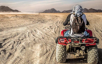 ATV quad bike rider on desert safari at sunset, Sharm El Sheikh.