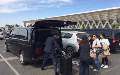 Private transfer service loading luggage at Marrakech airport.