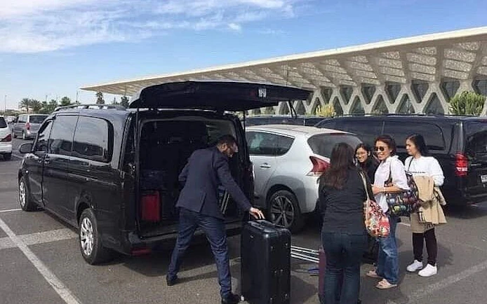 Private transfer service loading luggage at Marrakech airport.