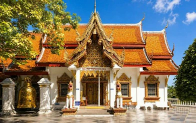 Wat Doi Suthep temple entrance with ornate roof and statues, Chiang Mai.