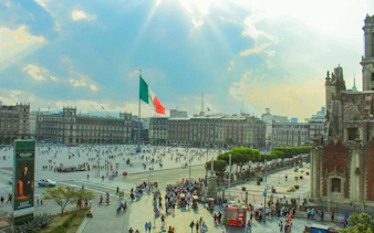 Zócalo square with Mexican flag and historic buildings, Mexico City Centro Histórico.