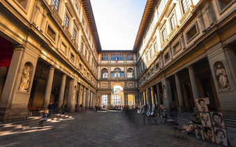 Uffizi Gallery courtyard in Florence, part of a self-guided walking tour on mobile app.