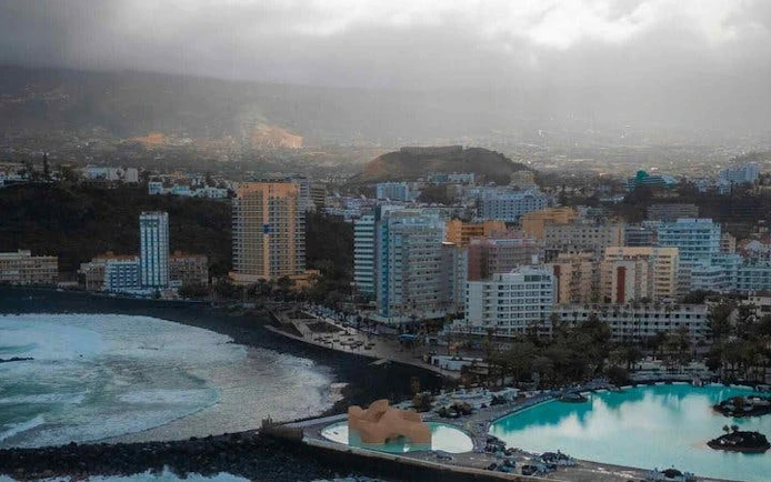 Tenerife coastal cityscape with ocean view and resort buildings.