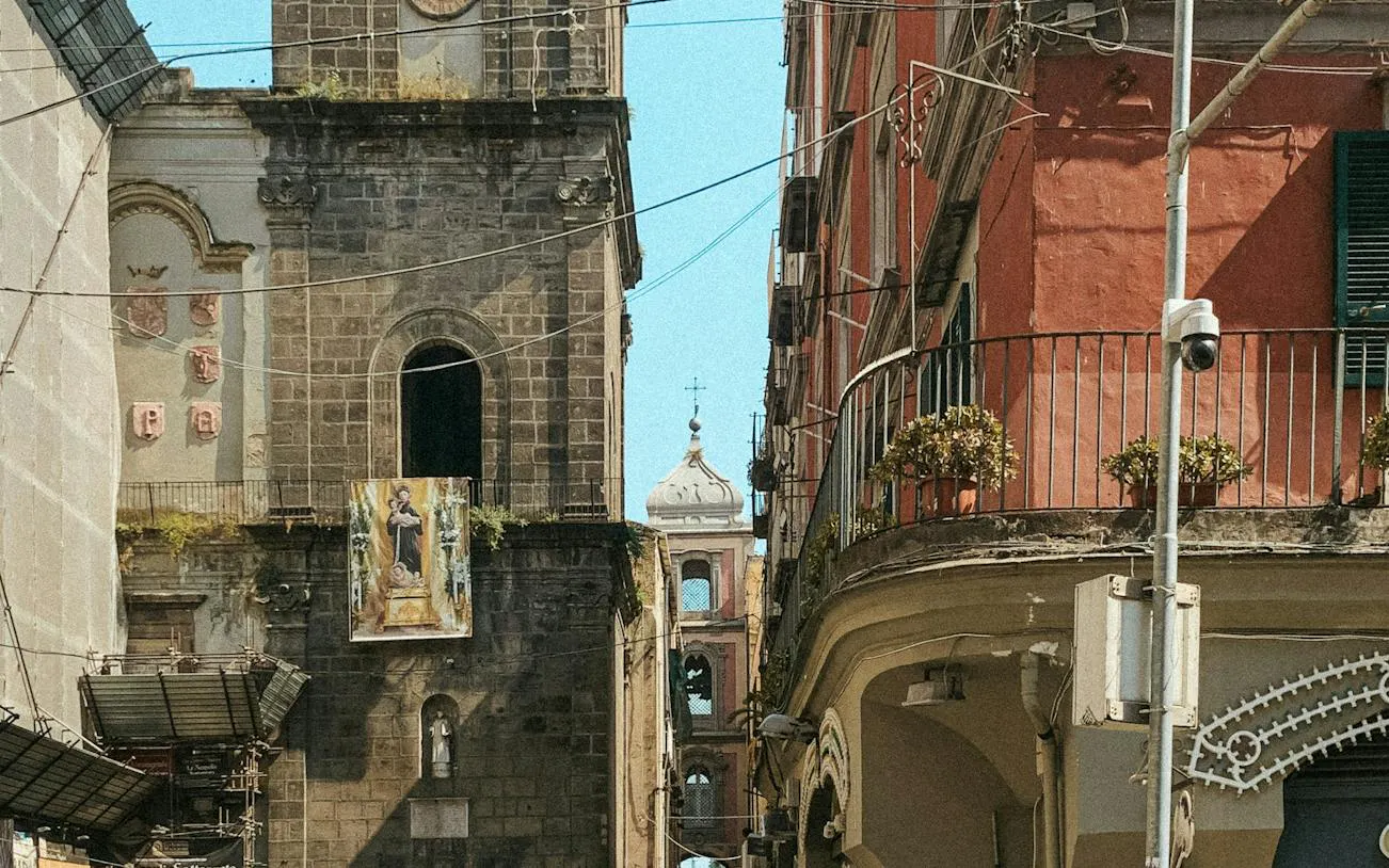Historic buildings along Spaccanapoli street in Naples, featuring a church facade and balcony.