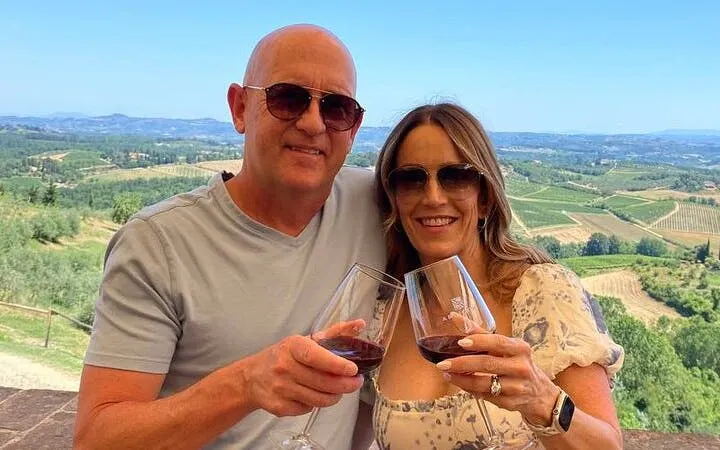 Couple enjoying wine with a view of Tuscan vineyards on a day trip from Rome.