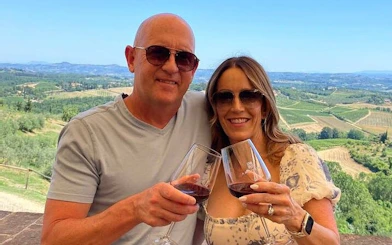 Couple enjoying wine with a view of Tuscan vineyards on a day trip from Rome.