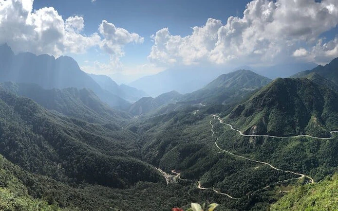 Mountain view of Sa Pa with winding roads and lush greenery, highlighting the Cat Cat Village tour.