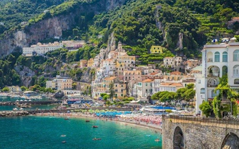 Sorrento coastline with colorful buildings and beach, viewed from the sea.