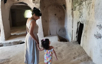 Mother and child exploring ancient cave interior in Cappadocia.
