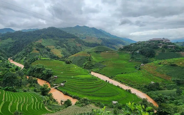 Terraced rice fields in Mu Cang Chai with river and mountains in the background.