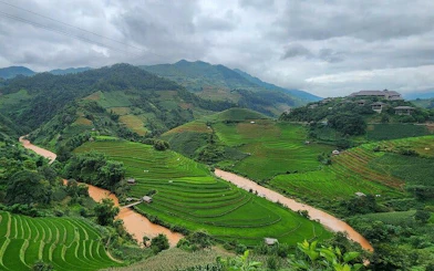 Terraced rice fields in Mu Cang Chai with river and mountains in the background.