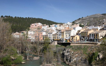 Cuenca hillside view with colorful houses and river, part of self-guided walking tour.
