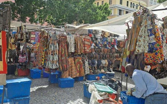 Outdoor market with colorful clothing and hats on display, Cape Town Private Shopping Tour.