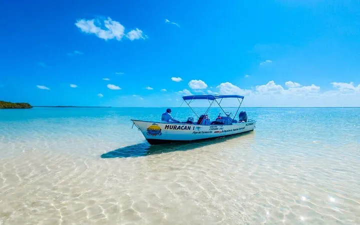 Boat on clear waters in Sian Ka'an, Tulum, part of a tour offering swimming, snorkeling, and lunch.