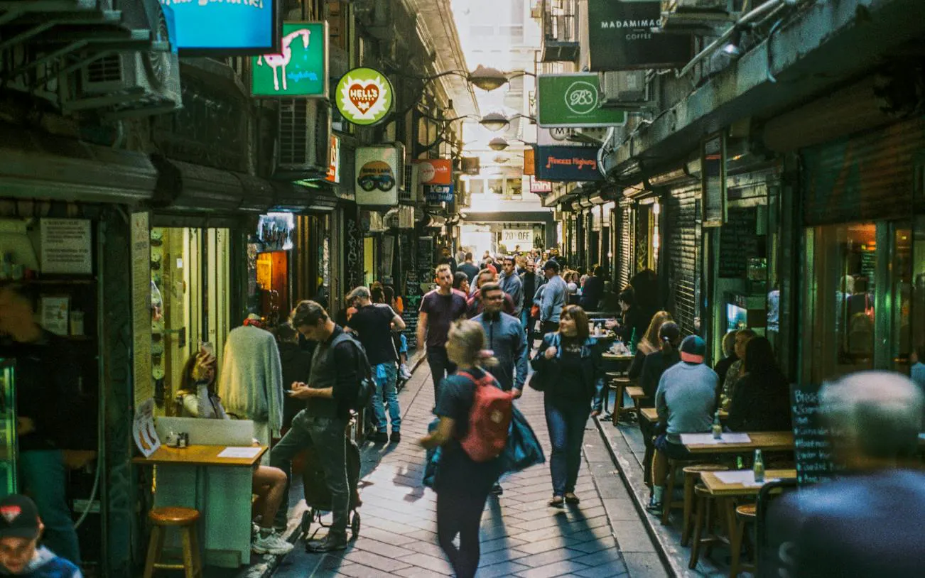 Crowded Melbourne laneway with cafes and shops, part of self-guided audio walking tour.
