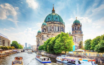 Berlin Cathedral and Spree River with boats, featured in self-guided walking tour app.