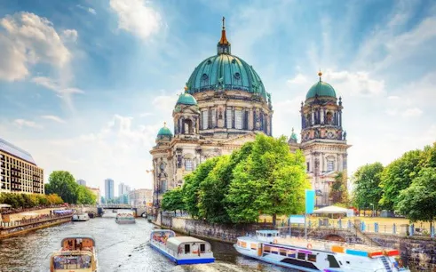 Berlin Cathedral and Spree River with boats, featured in self-guided walking tour app.
