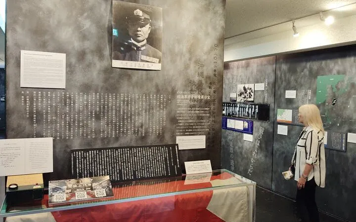 Naha WWII Navy Underground HQ exhibit with historical documents and visitor.