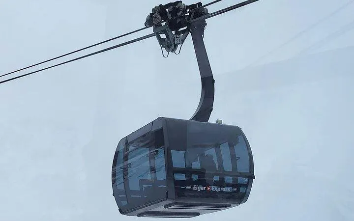 Eiger Express cable car ascending in snowy Jungfraujoch, Switzerland.