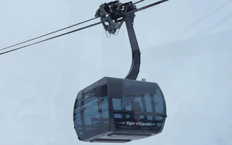 Eiger Express cable car ascending in snowy Jungfraujoch, Switzerland.