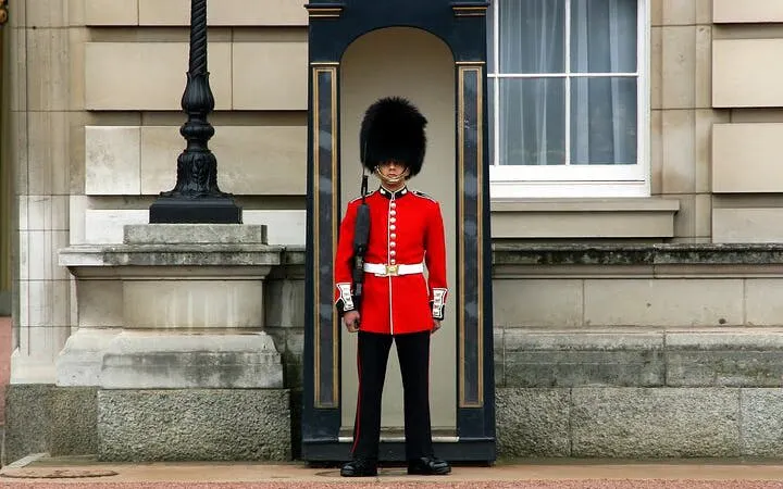 Royal guard in red uniform at Buckingham Palace during Changing of the Guard, London.