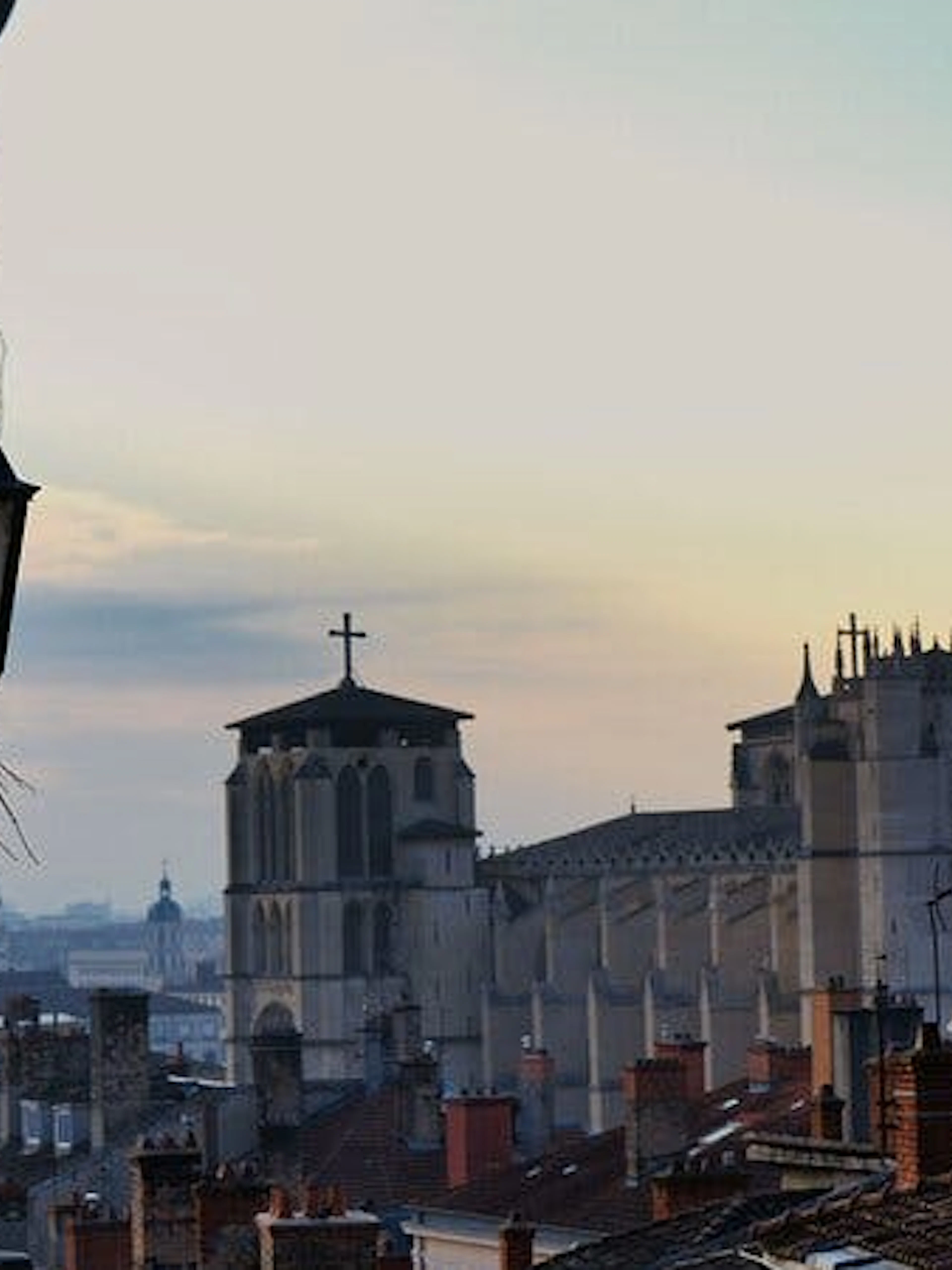 Lyon skyline with Gothic cathedral at sunset, part of Haunted Lyon exploration game.