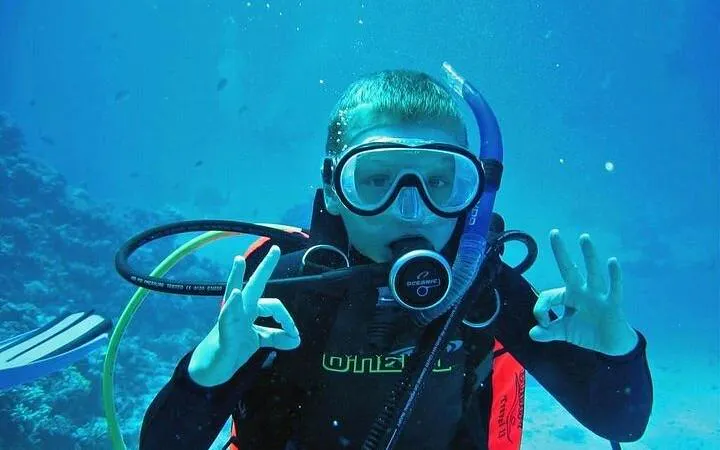 Scuba diver giving OK sign underwater at Tiran Island, Sharm El Sheikh.