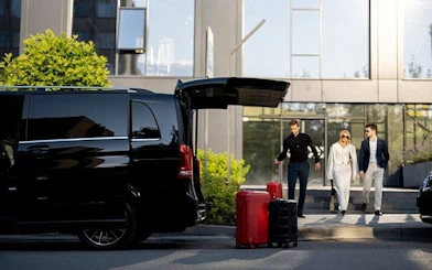 Private transfer vehicle with open trunk and luggage, passengers approaching, Marrakesh to Agadir.